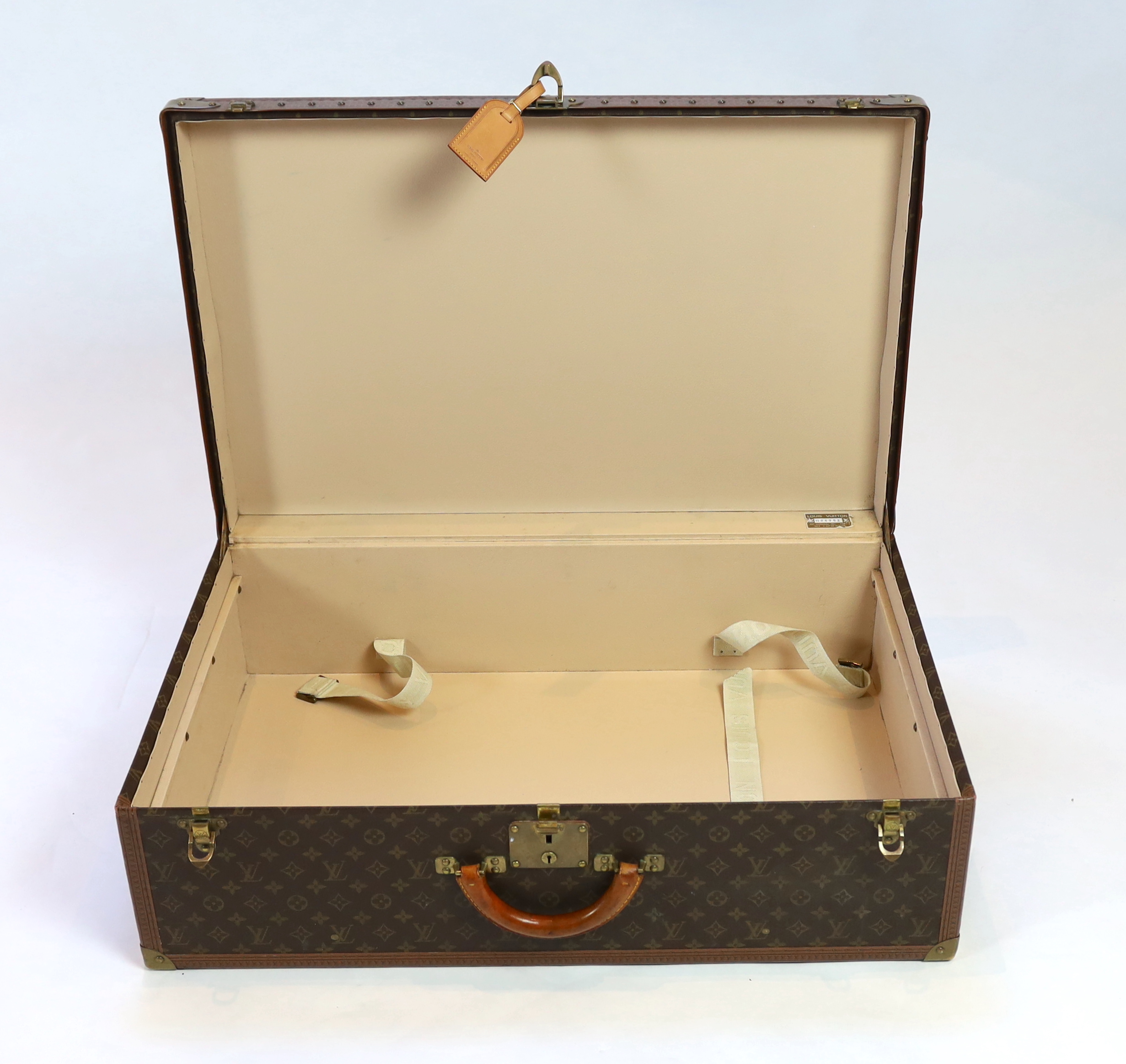 A Louis Vuitton monogram canvas and tan leather suitcase, width 81cm, depth 26cm, height 52cm